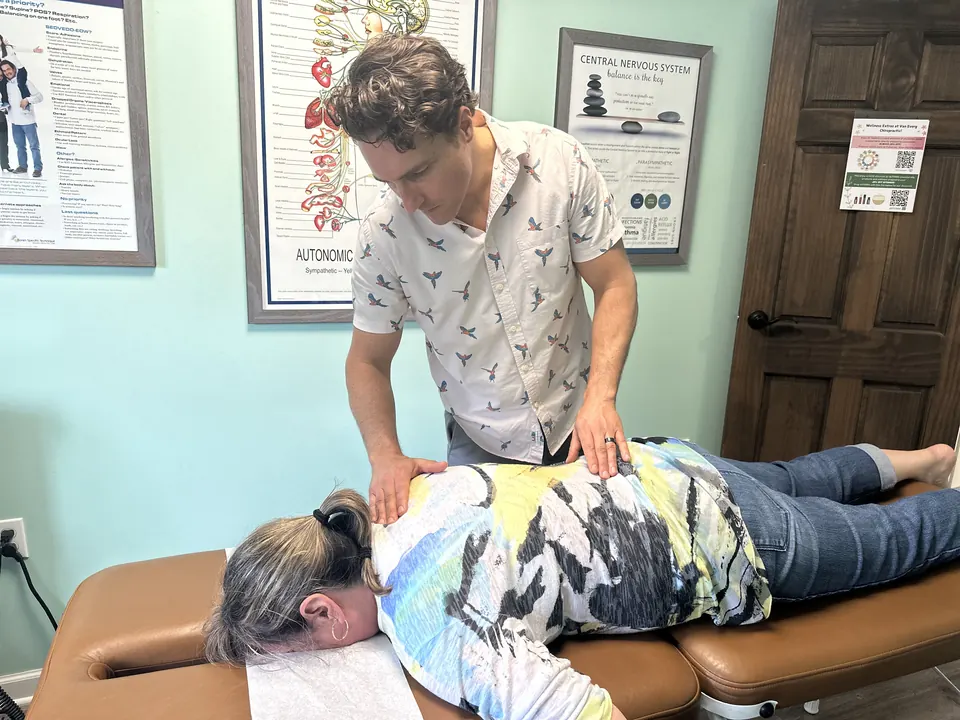 Dr. Zach Conner resting both hands on a patient's back during a gentle adjustment