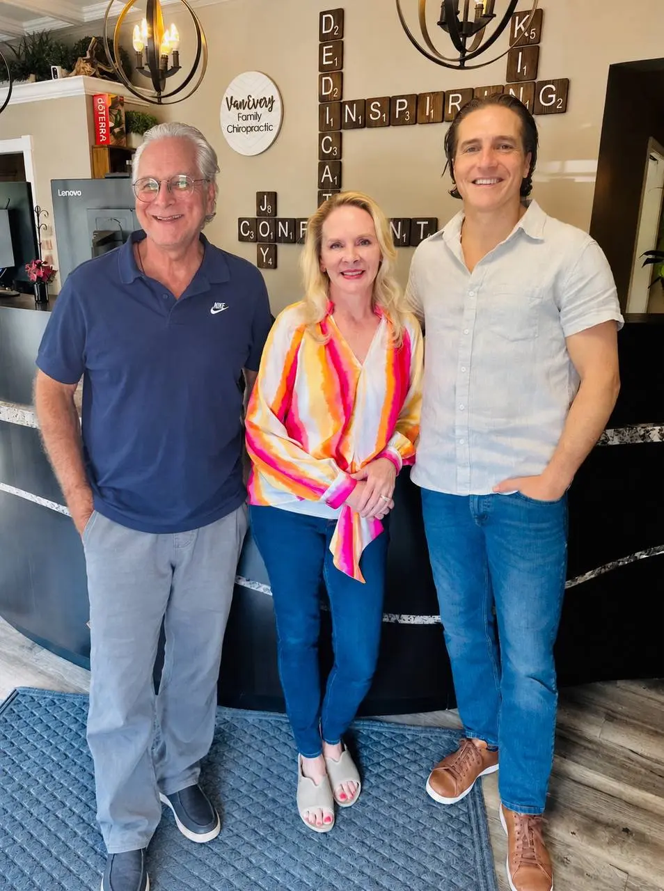 Dr. John Johr, Dr. Anna Saylor and Dr. Zach Conner smiling together at the Van Every front desk